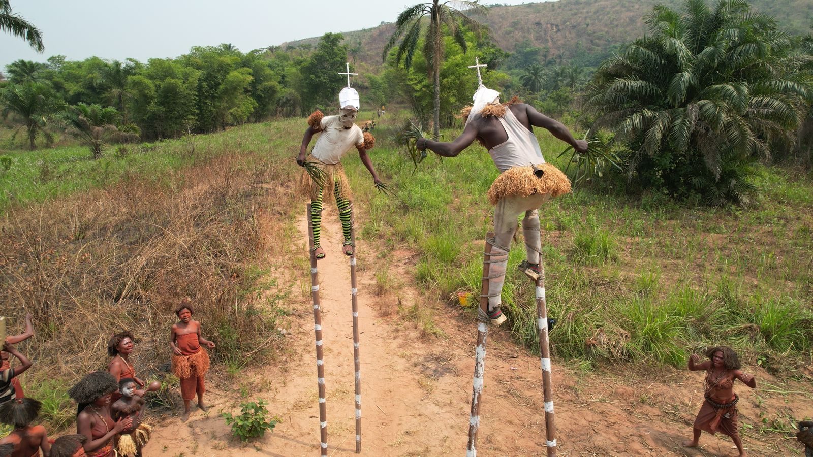 Stilt walkers on a forest track