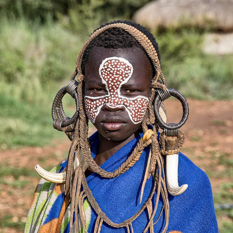 Woman with a painted face and beaded collar