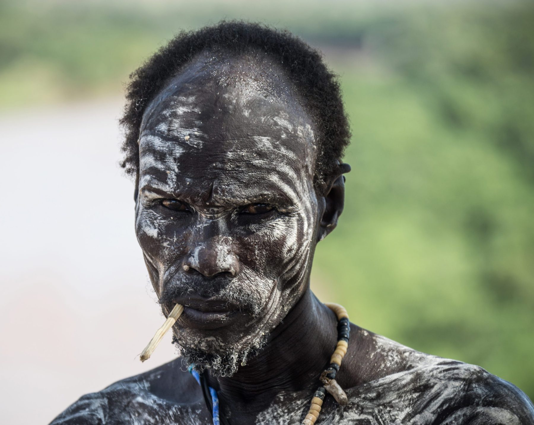 Man with a face painted in white clay