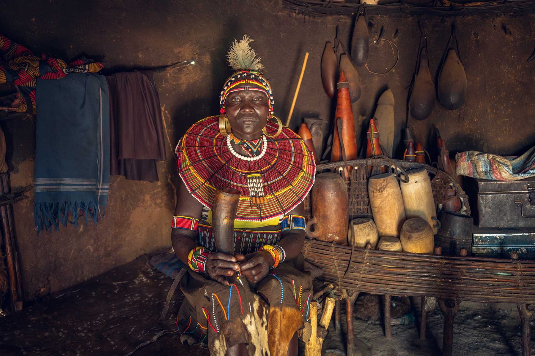 Woman in traditional beadwork inside a home