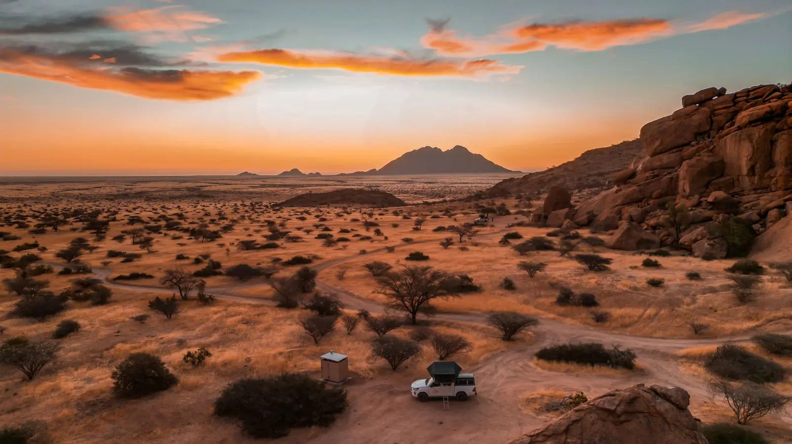 Sunset over the desert with a camp below